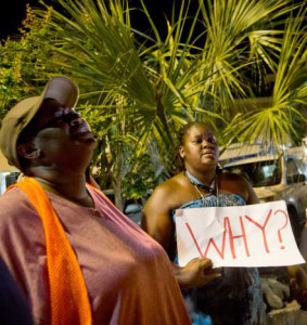 Woman holds a sign, asking why, after the church violence in Charleston